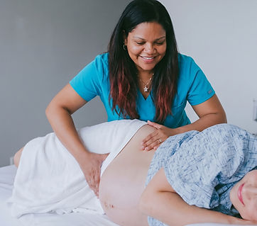 Healthcare provider examining a pregnant person's belly.