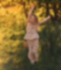 Happy girl jumping in a grassy field