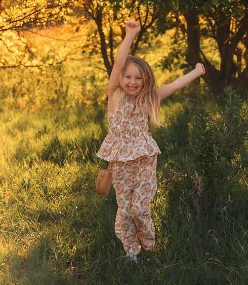 Happy girl jumping in a grassy field