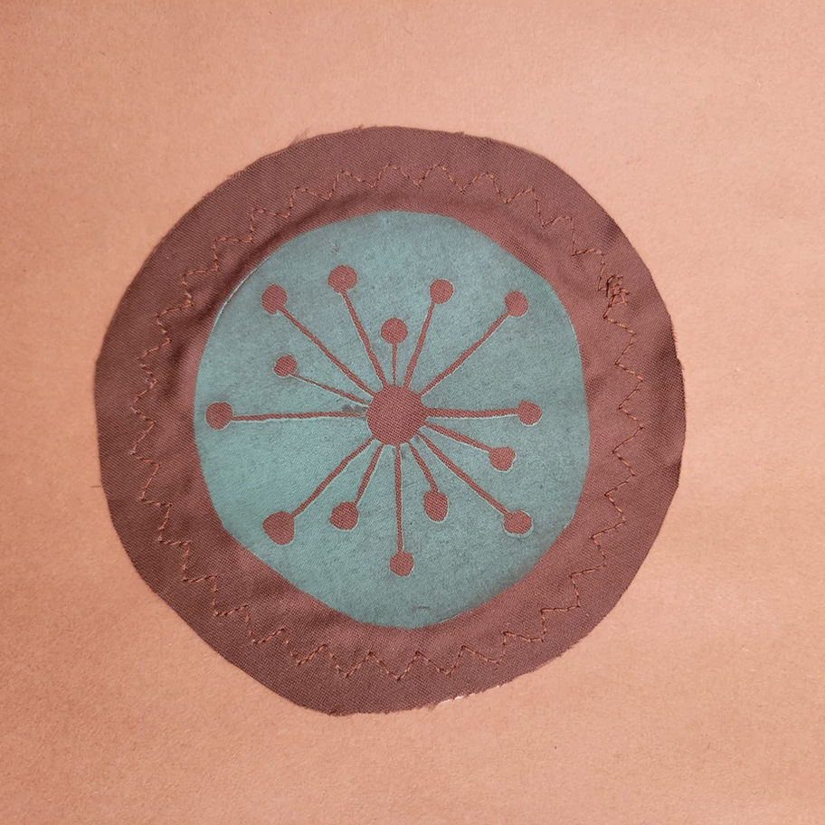 Green atomic starburst on a brown patch with invisible stitching.