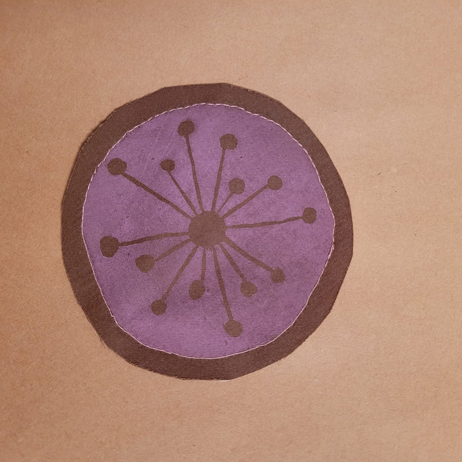 Pink atomic starburst on a brown patch with pink stitching.