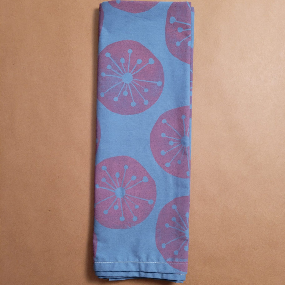 Close-up of blue cotton bandanna featuring hand-printed pink mid-century atomic starburst circles