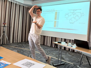 Ein Mann der vor einer Leinwand eine Präsentation hält und gestikuliert