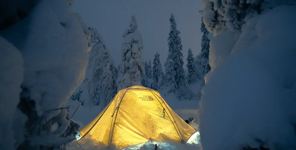 Upplyst tält i snötäckt skog