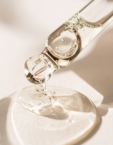 Firefly_A high-resolution close-up of a glass dropper releasing a clear, viscous liquid wi