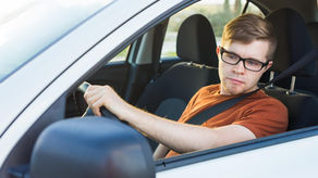 Teenage driver checking side mirror before changing lanes.
