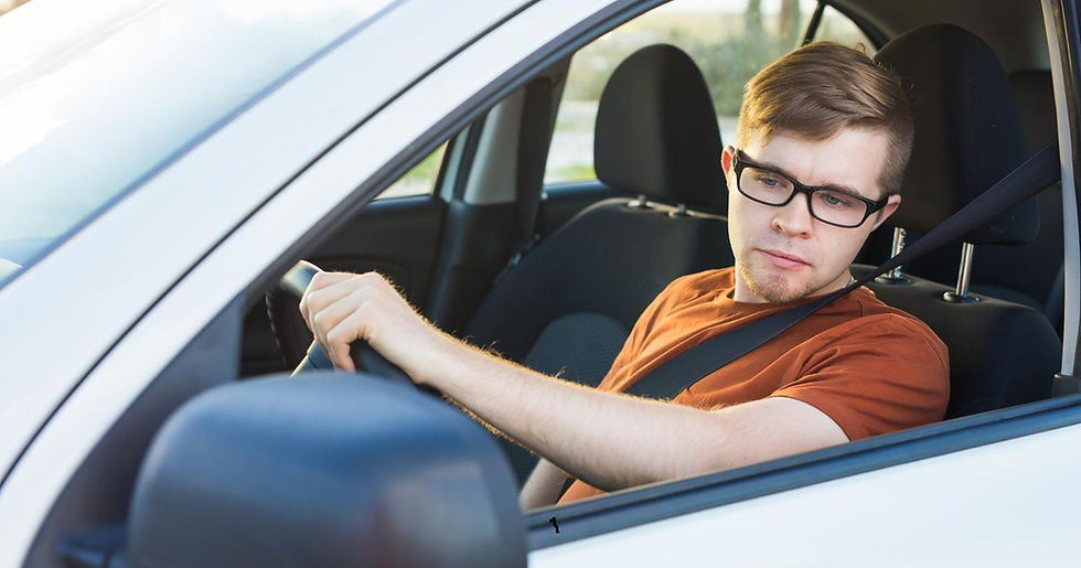 Teenage driver checking the side mirror before changing lanes.