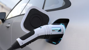 Electric car parked at charging station with plug connected — federal EV tax credit ending September 2025.