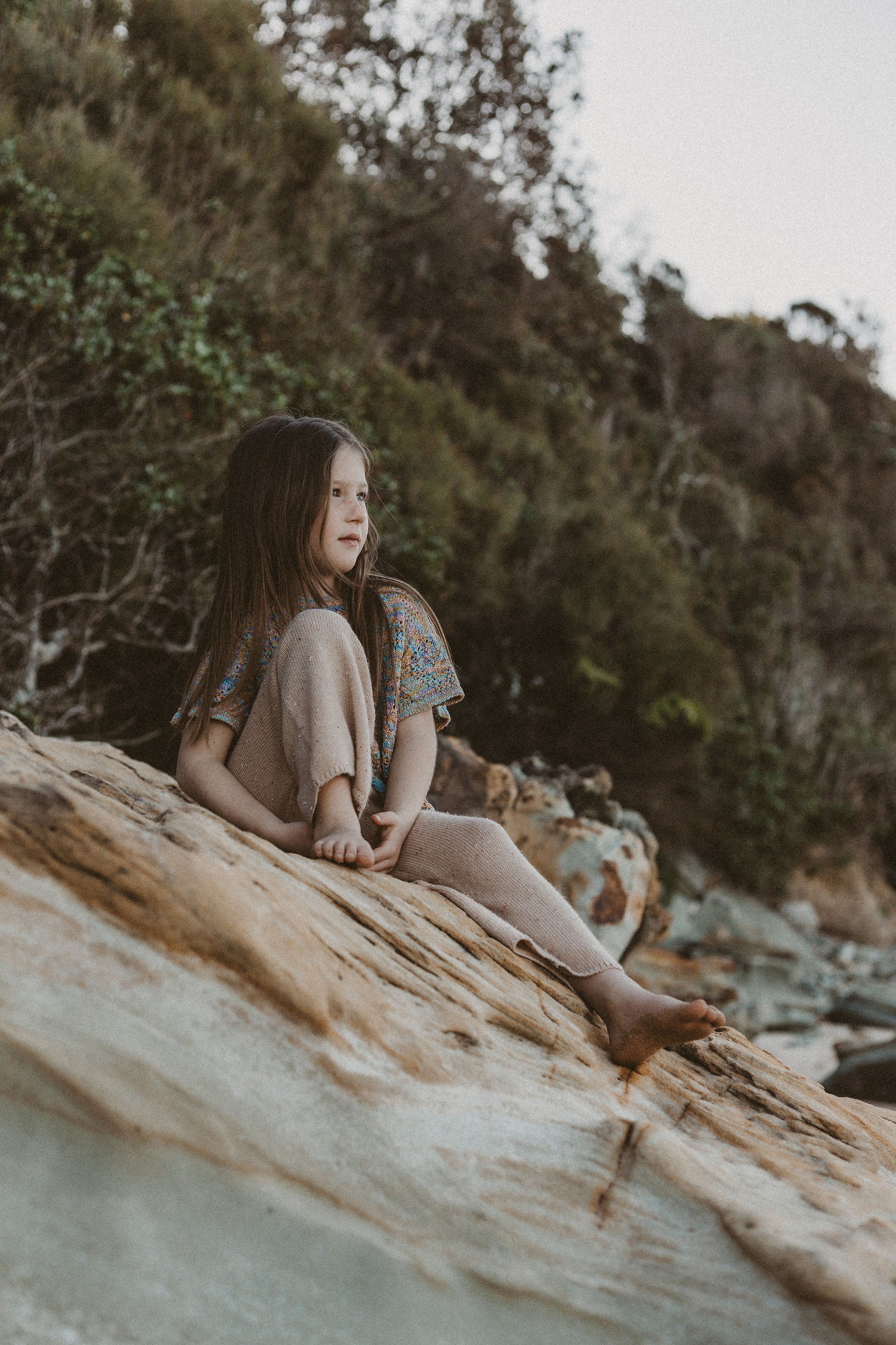 little girl sitting on rock