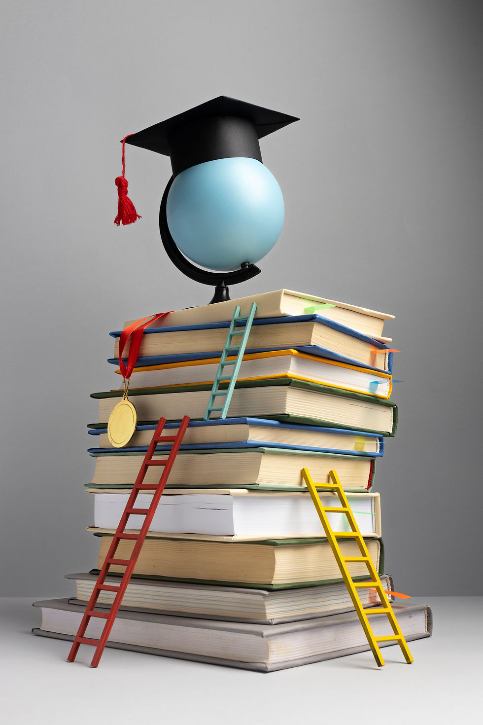 front-view-stacked-books-graduation-cap-ladders-education-day.jpg