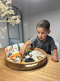 Child exploring a sensory learning kit with hands-on materials, supporting fine motor and early literacy development.