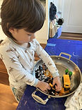 Child exploring a sensory learning kit with hands-on materials, supporting fine motor and early literacy development.