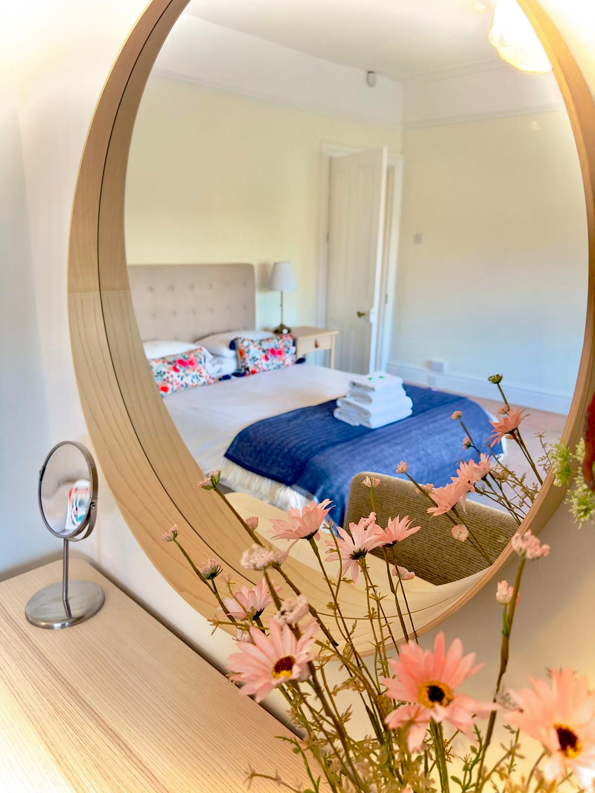 Mirror reflection of bedroom with flowers