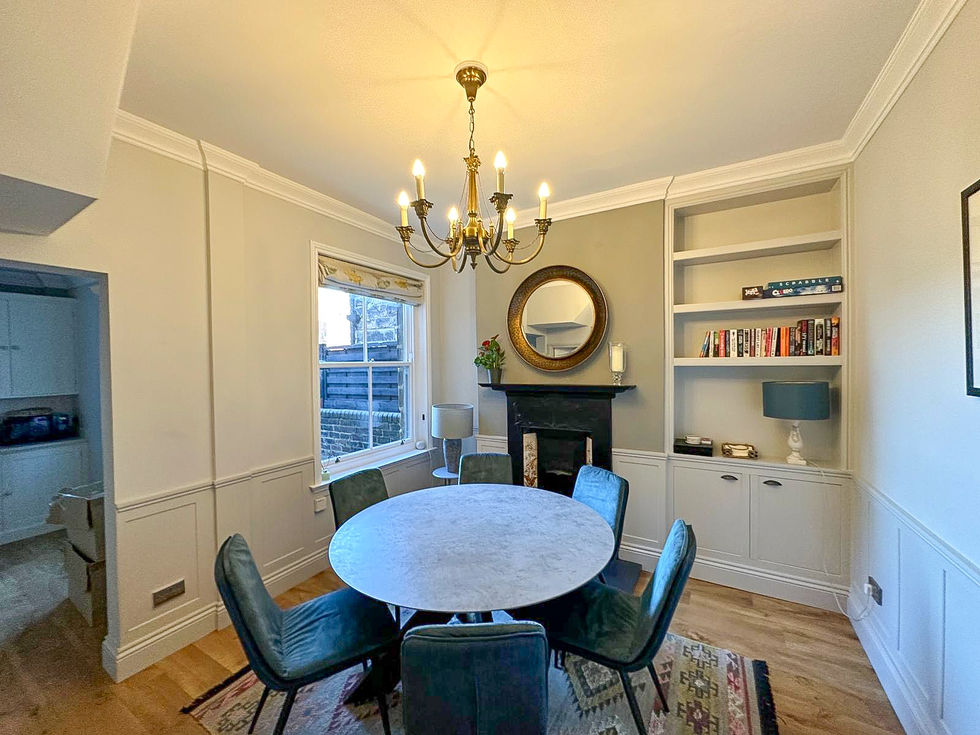 Elegant dining room with round table, chandelier, and built-in shelving