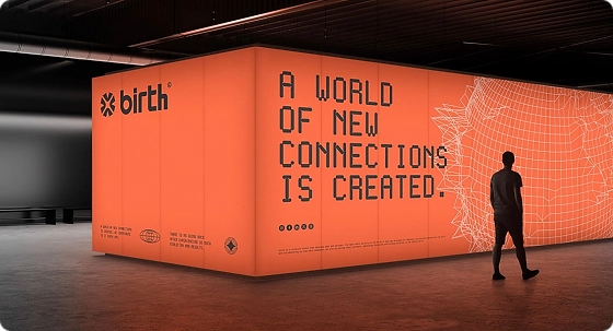 Person standing in front of a large orange digital installation with geometric patterns in a modern, industrial-style exhibition space for Newrite retail and trade show concept creation service.