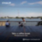 Three people on a wooden terrace by a river, a woman helps a child stand. Overcast sky. Text: "Take a coffee break, Hiddenwoods Cafe."