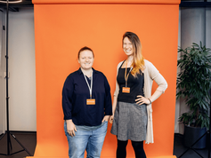 Two aspiring founders in front of an orange wall