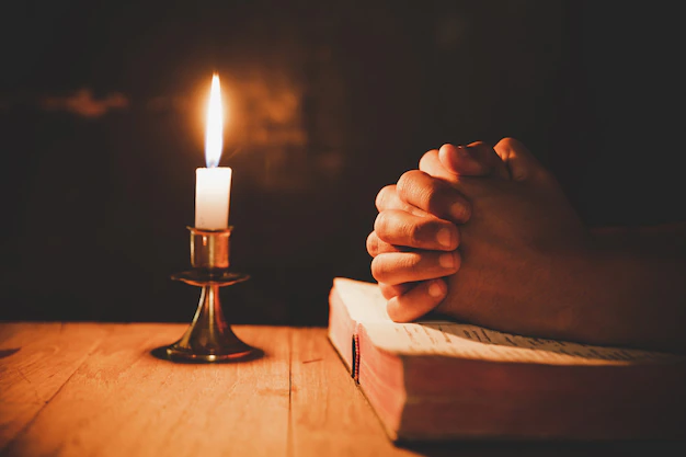 hombre-orando-biblia-velas-ligeras-enfoque-selectivo_1150-9240.webp