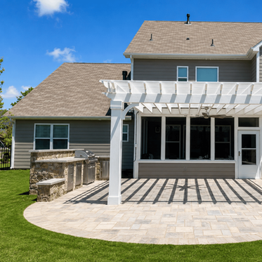 Curved paver patio with stone outdoor kitchen and white pergola attached to screened porch in Charlotte NC
