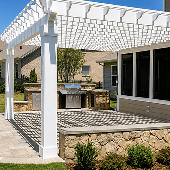 Stone outdoor kitchen with built-in grill under white pergola on paver patio beside screened porch in Charlotte NC
