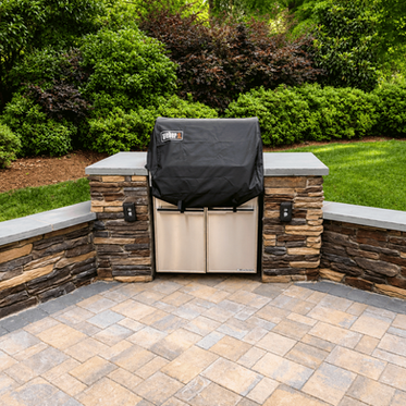 Built-in Weber grill in stacked stone island with seating walls on paver patio in Charlotte NC