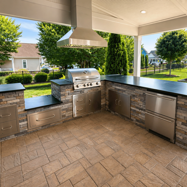 Covered outdoor kitchen with L-shaped stacked stone counters, black granite tops, and stainless range hood in Charlotte NC