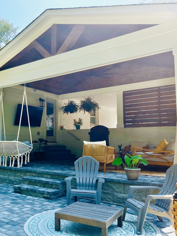 Stylish covered patio with hanging swing, seating area, and paver flooring, designed for outdoor entertaining in Charlotte.