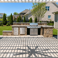 Custom stone outdoor kitchen with built-in grill, sink, and storage drawers on paver patio in Charlotte NC