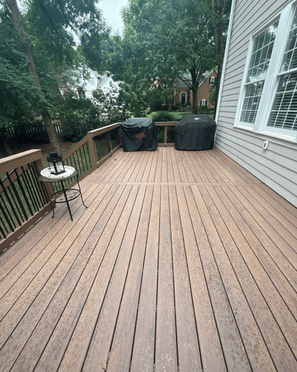 Long composite deck walkway along side of home with railing