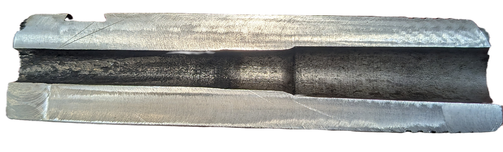 Close-up of a metallic object with a grooved, dark center and shiny silver edges. The surface has a textured, machined finish.