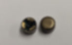 Two small, round, metallic objects on a white surface. One has visible inner components, while the other is smooth and closed.