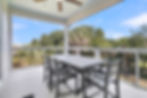 Screened porch with dining table and lush outdoor view