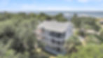 White multi-story beach house with balconies near the ocean