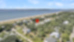 Aerial view of coastal community with beach, ocean, and map pin