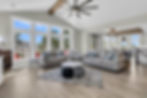 Open concept living room with light decor, large windows, and exposed beams