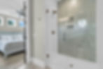 Bathroom with glass shower and view of bedroom