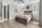 Modern bedroom with wooden bed, light gray walls and fan