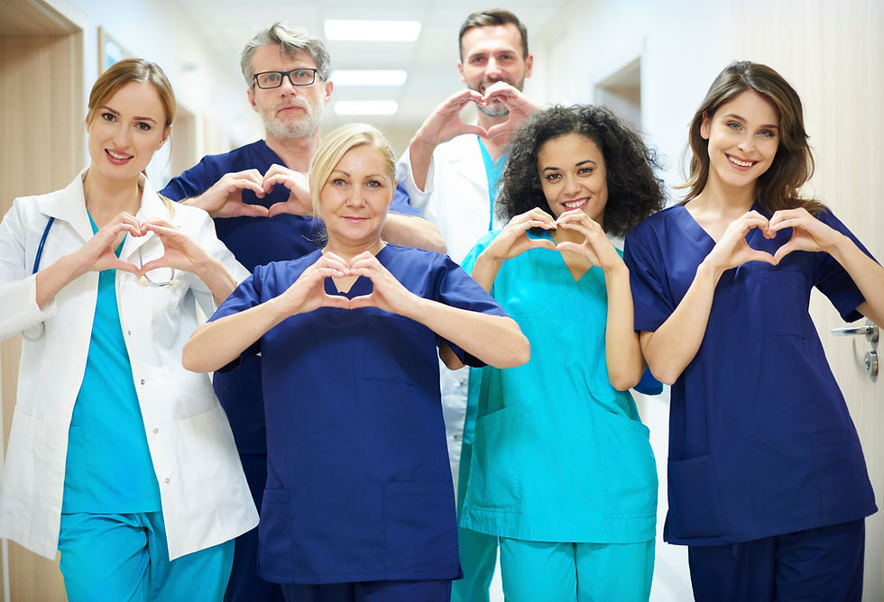 group of health care professionals showing a heart symbol with their hands
