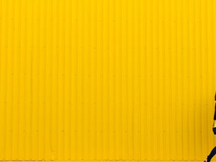 Frau vor gelber Fassade mit viel Freiraum im Bild als modernes Keyvisual für einen Überblick zum Wahlprogramm.