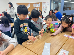 Campers playing with Jenga blocks in class
