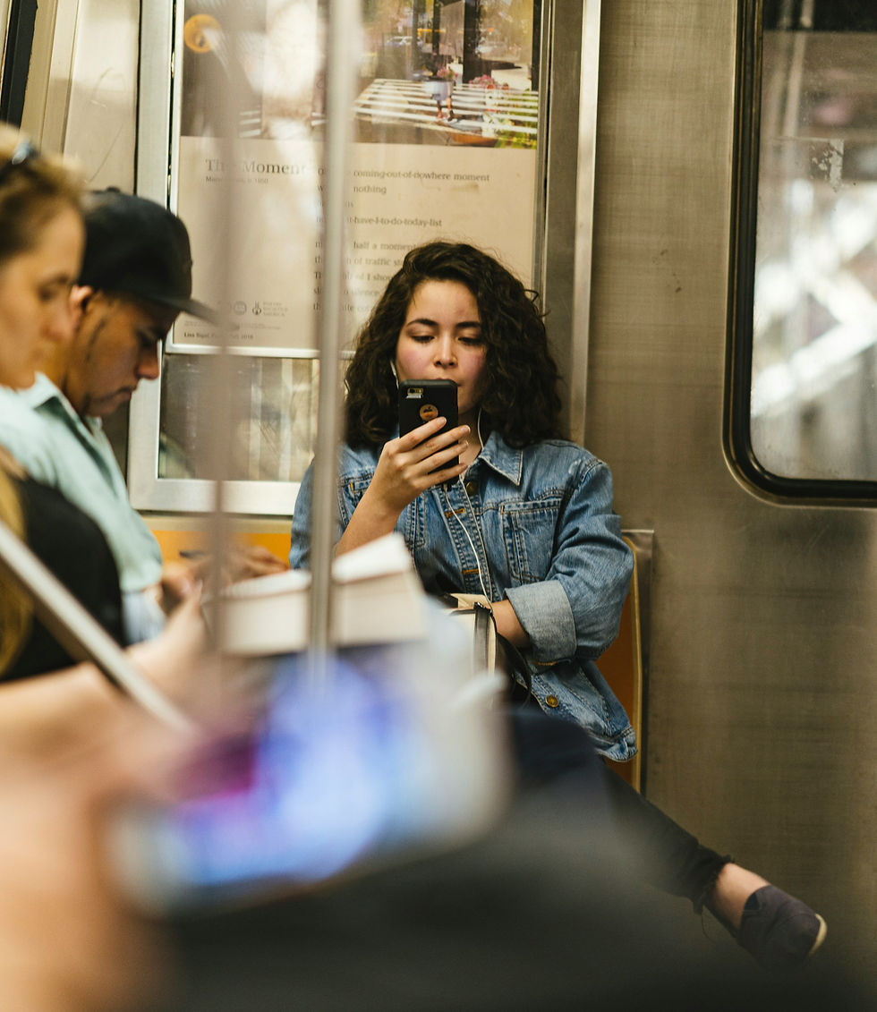Woman on subway train looking at her phone while commuting, focused on screen instead of surroundings