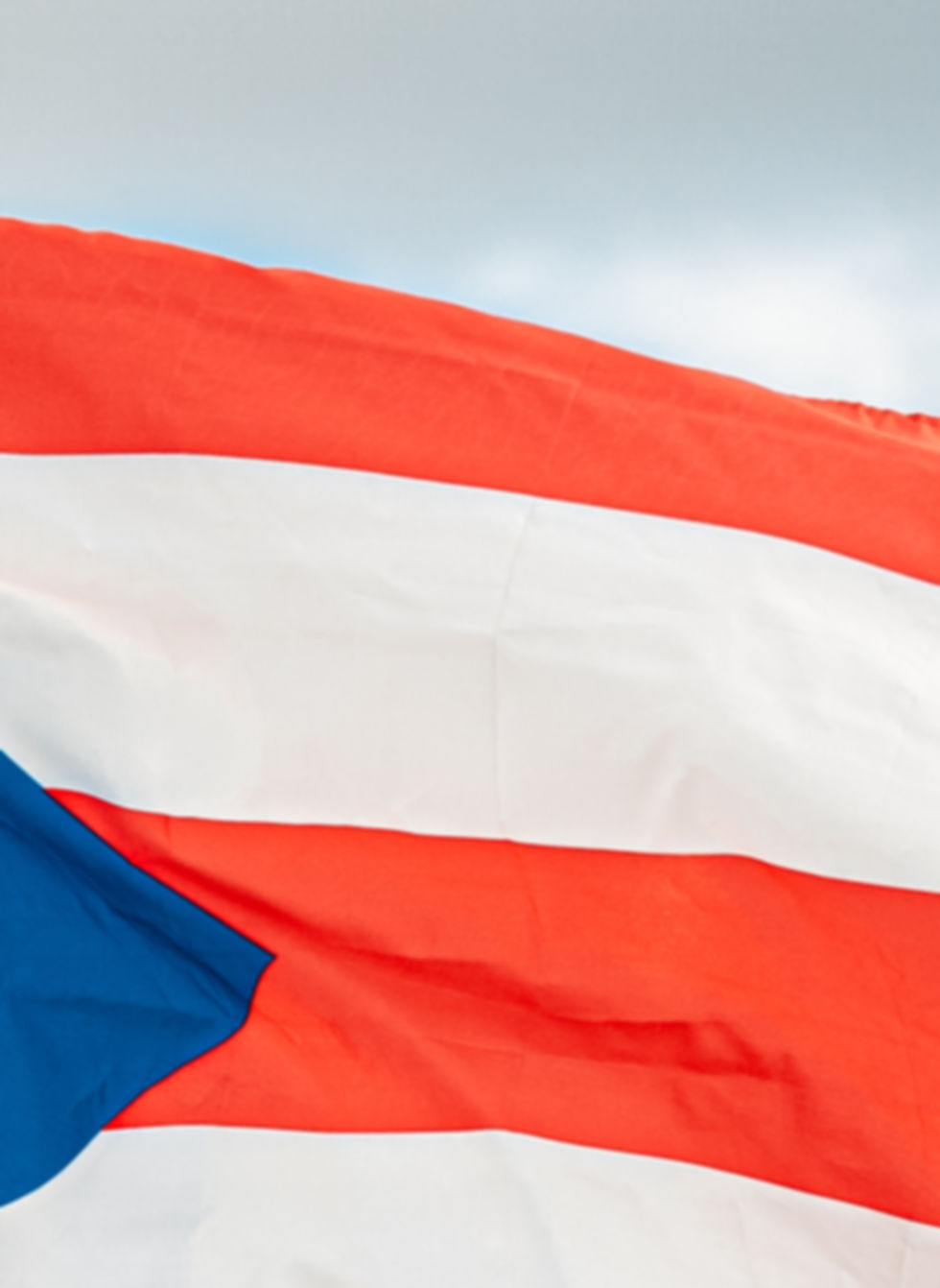Puerto Rican flag flowing in the blue sky wind.jpg