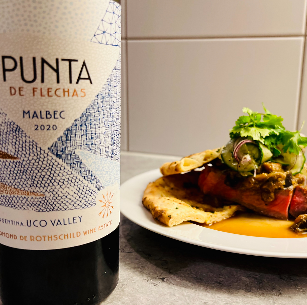 Bottle of red wine with beef curry and naan bread