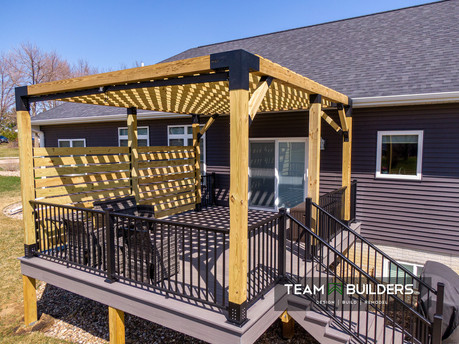 Custom composite deck with attached treated pergola and privacy screen in Cedar Falls, IA