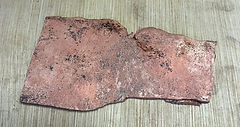 Uneven flat piece of patinated copper