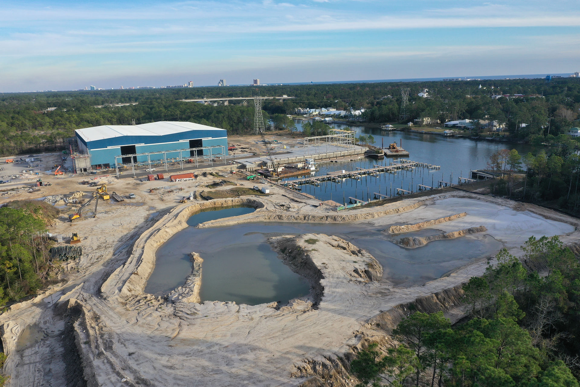 Aerial view of new construction at Legendary Marina & Yacht Club, showcasing boat slips, a dry storage facility, and the vibrant progress of the waterfront development.