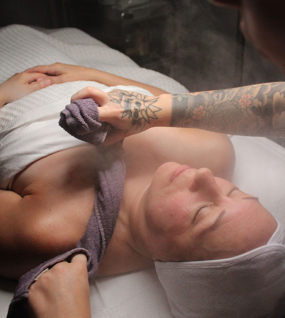 A client receiving gentle facial steam during a hydrating skincare treatment, with warm vapor softening the skin and preparing it for extractions and nourishing products.
