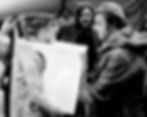 Tactile Accountability: VALIE EXPORT staging her historic 'Tap and Touch Cinema' on a European street in 1968, forcing direct, unwavering eye contact with participants to shift the power dynamic from passive media voyeurism to acute personal responsibility.