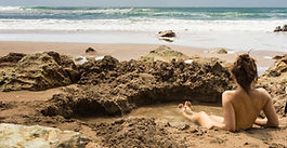 A woman relaxes in a self-dug geothermal pool at Hot Water Beach, Coromandel, New Zealand.
