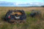 The Staging Pile: A closer view of the extracted vehicle wreck showing registration DKA807, bundled alongside coils of wire fencing and wooden posts on the reserve margin for consolidated trailer removal by Department of Conservation staff.